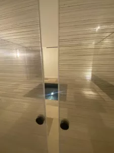 Deux panneaux vitrés à fines trames horizontales avec boutons de tirage sombres.
