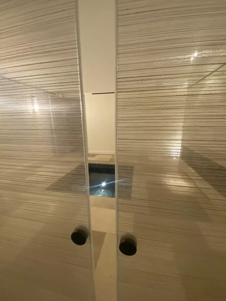 Deux panneaux vitrés à fines trames horizontales avec boutons de tirage sombres.